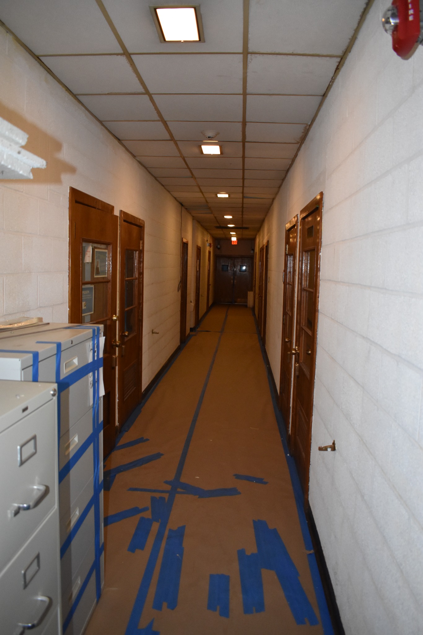 Hallway flooring and cabinets covered with protection during preparation