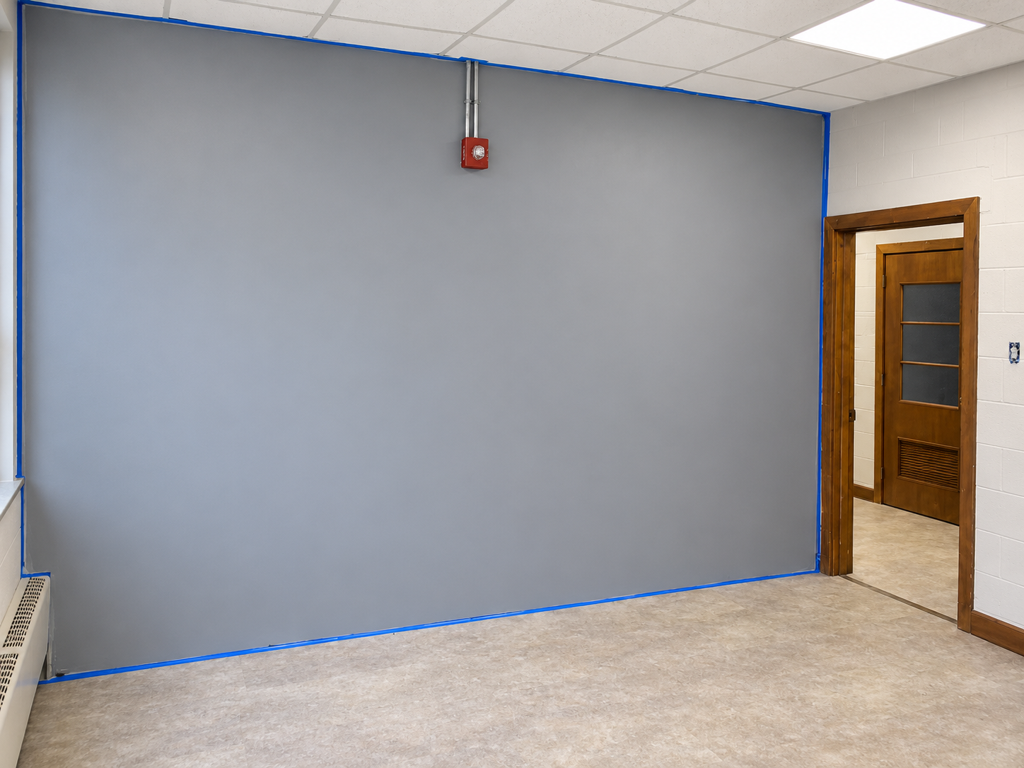 Digitally retouched presentation of office wall finishing with blue painter's tape.