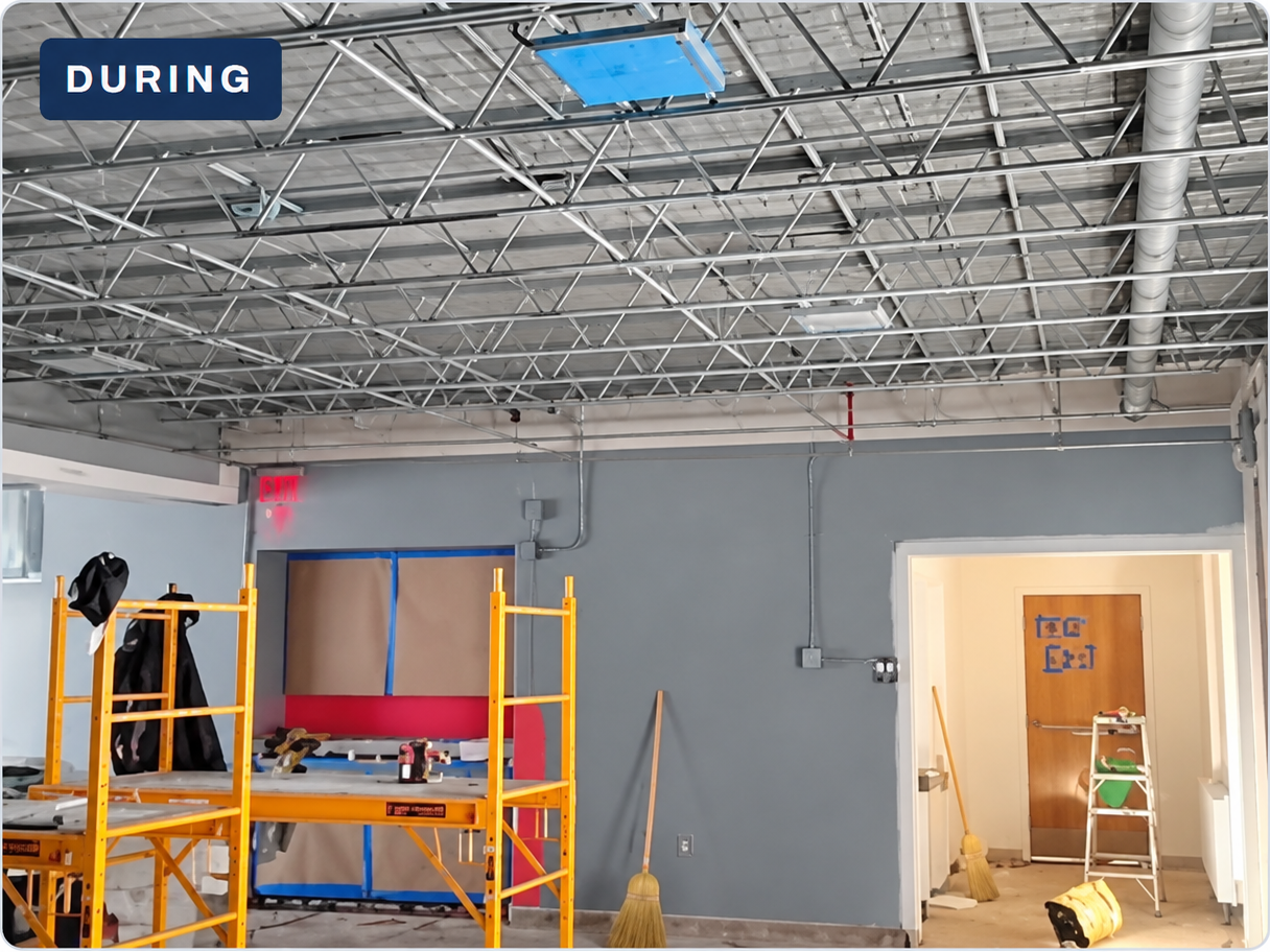 Wide view of daycare overhead and wall work with scaffolding in the room