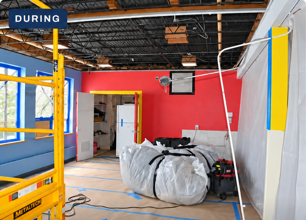 Daycare room during ceiling removal with exposed structure, scaffold and bagged material
