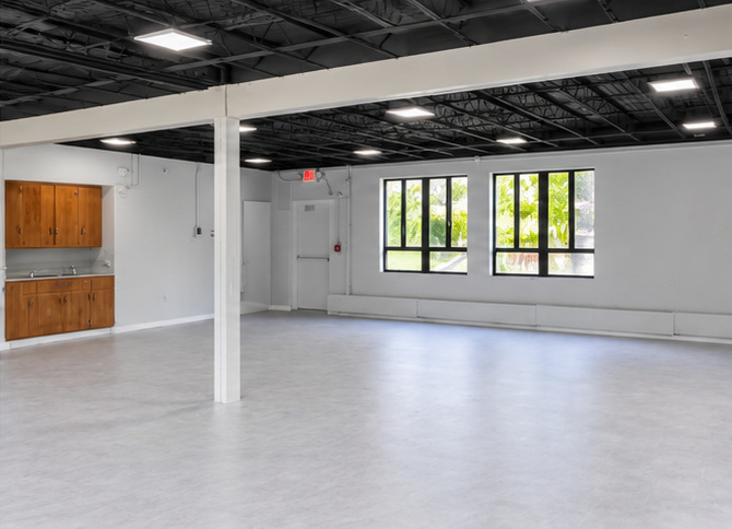 Daycare room with cabinetry, sink, large windows and a central column